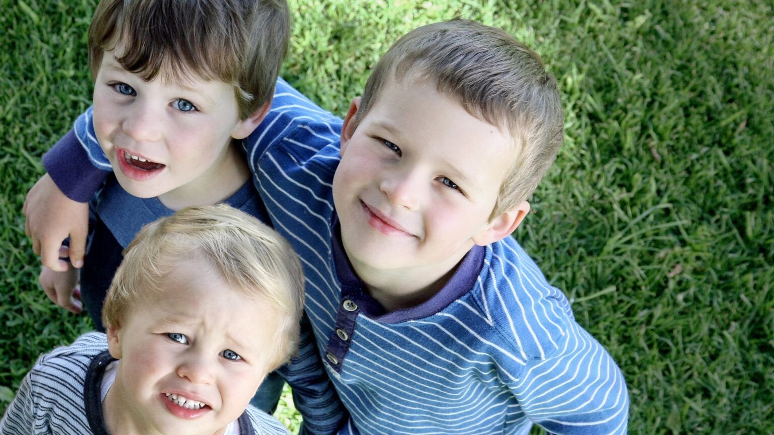 A group of children, including children with autism, standing together on the grass during outdoor play. The image highlights inclusion, social interaction, and the importance of physical activity for children on the autism spectrum