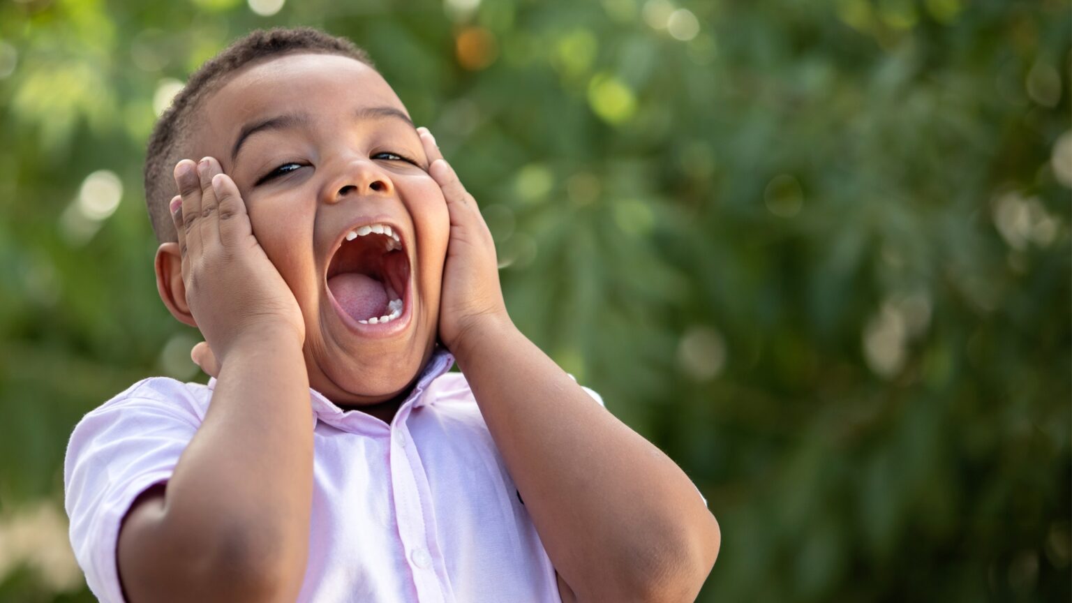 Child with autism with mouth open, possibly expressing excitement, curiosity, or sensory stimulation. The image reflects the diversity of expressions and behaviors in autistic children.